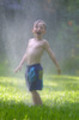 Thumbnail A little boy plays in a sprinkler in summer