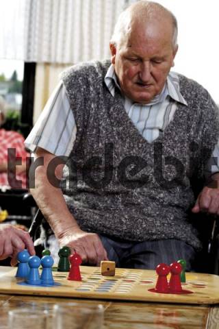Senior citizen playing a board game in an old-age home - Download P...